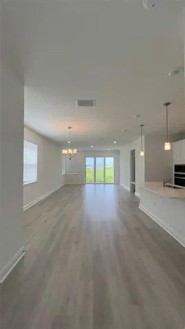 an empty room with wooden floor and entrance