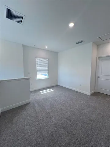 an empty room with a empty space & windows