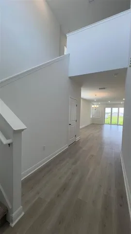 an empty room with wooden floor and mirror