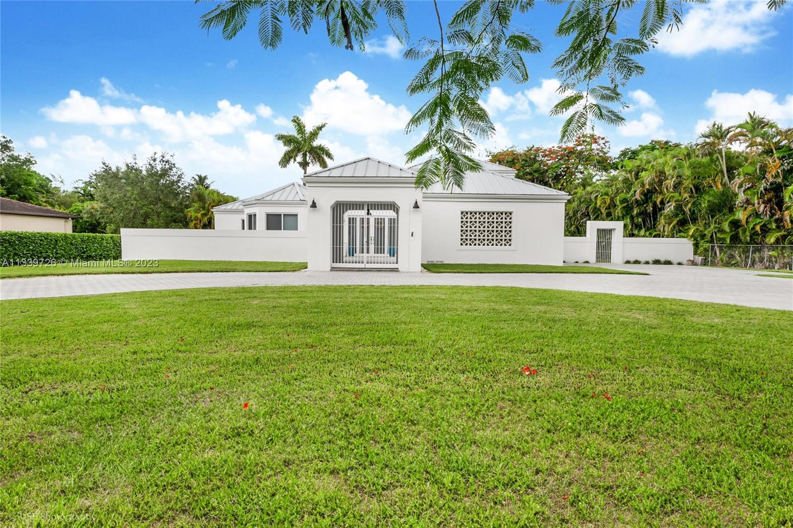 a front view of a house with a garden and yard