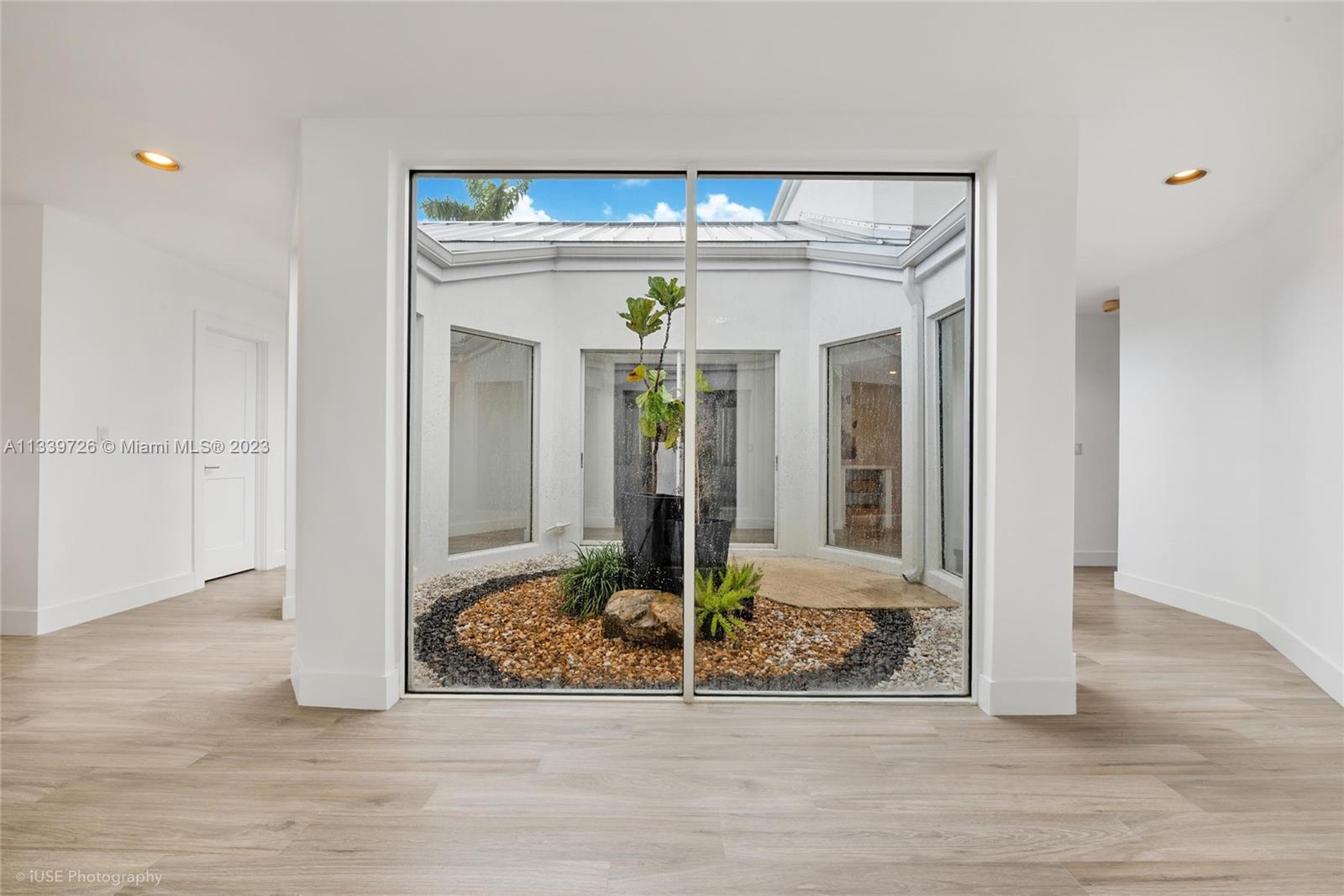 8528 Southwest 121st Street Miami, FL 33156 - Photo 3 of 26 a view of a hallway with wooden floor and chandelier