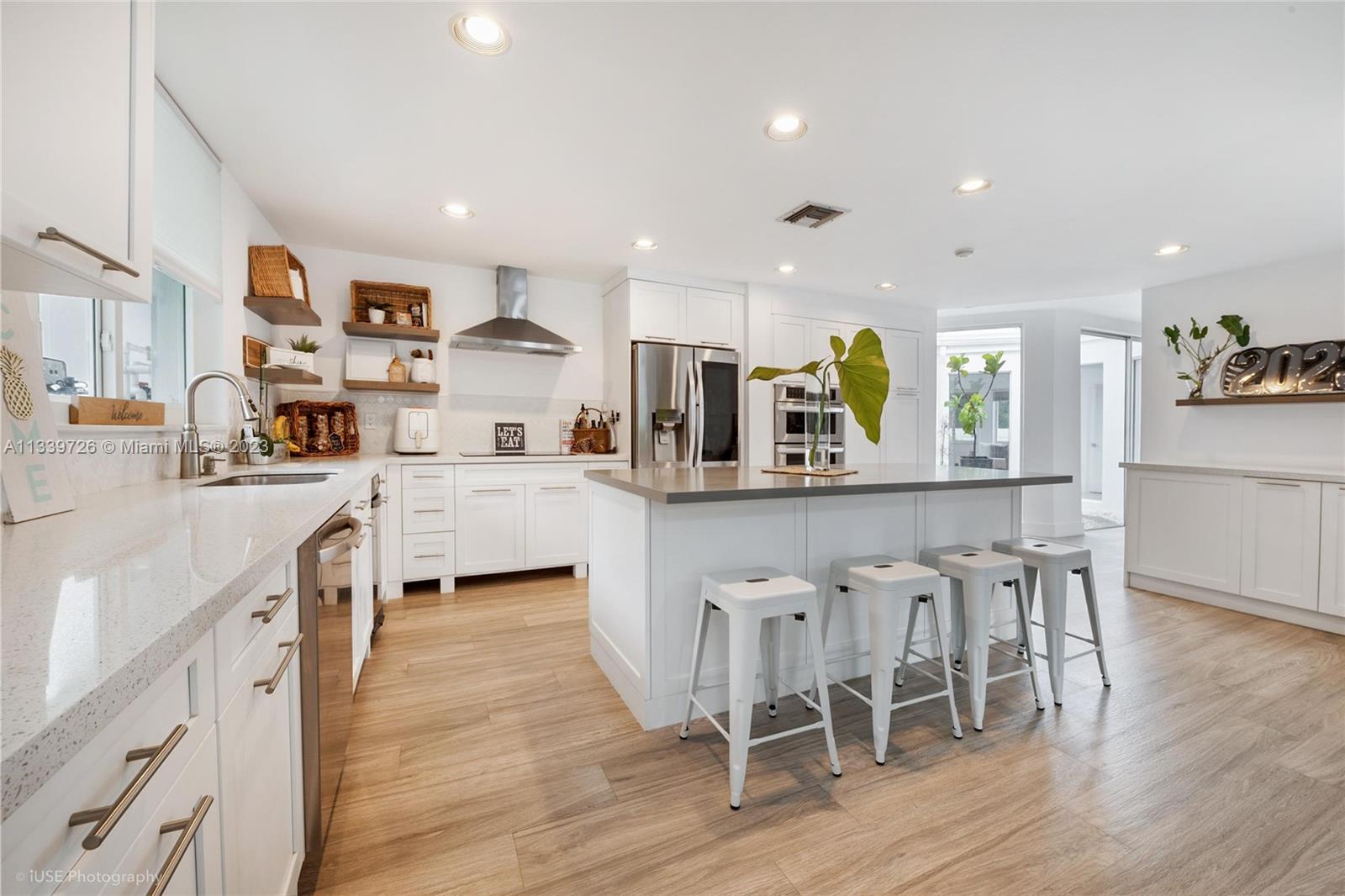 8528 Southwest 121st Street Miami, FL 33156 - Photo 8 of 26 a kitchen with stainless steel appliances kitchen island granite countertop a table chairs sink and cabinets