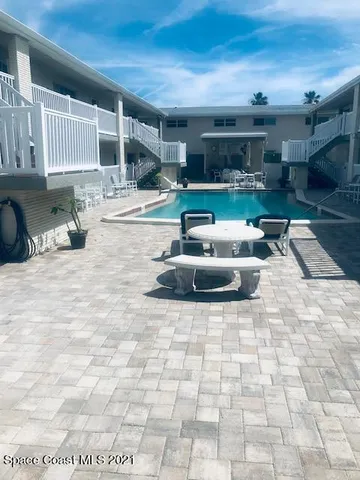 a living room with stainless steel appliances kitchen island granite countertop a sink and cabinets