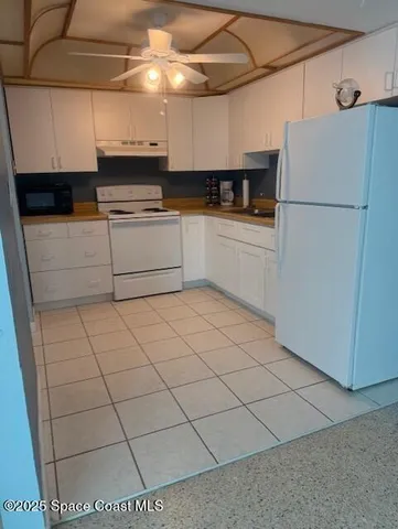 a kitchen with stainless steel appliances granite countertop a sink a stove a refrigerator and cabinets