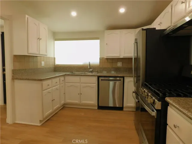 a kitchen with stainless steel appliances a stove sink and microwave