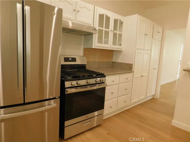a kitchen with stainless steel appliances white cabinets and a refrigerator