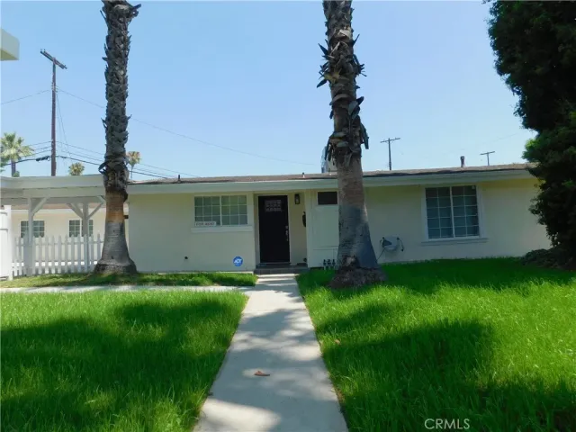 a front view of a house with a garden and yard