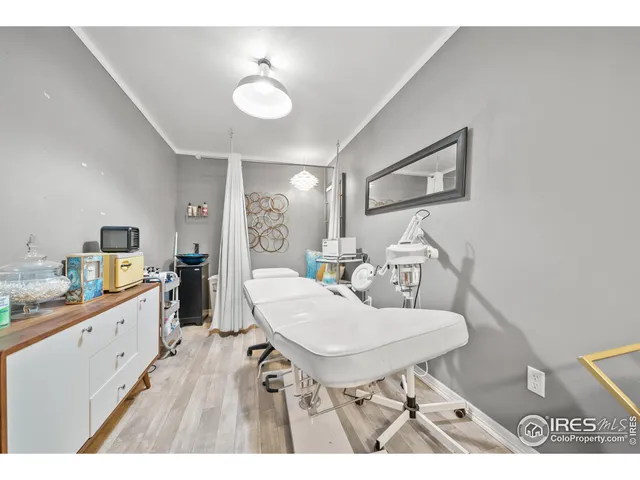 a open kitchen with stainless steel appliances kitchen island a table chairs sink and wooden floor