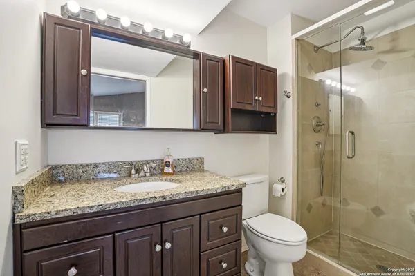 a bathroom with a granite countertop sink toilet and shower