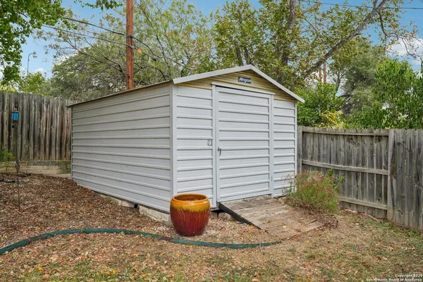a backyard of house with a washing machine and potted plants