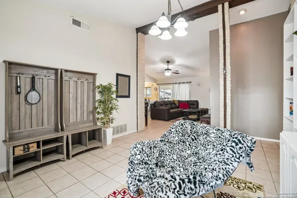 a living room with furniture a chandelier and a window