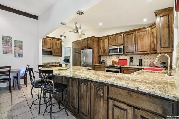 a kitchen with granite countertop a stove a sink and a refrigerator