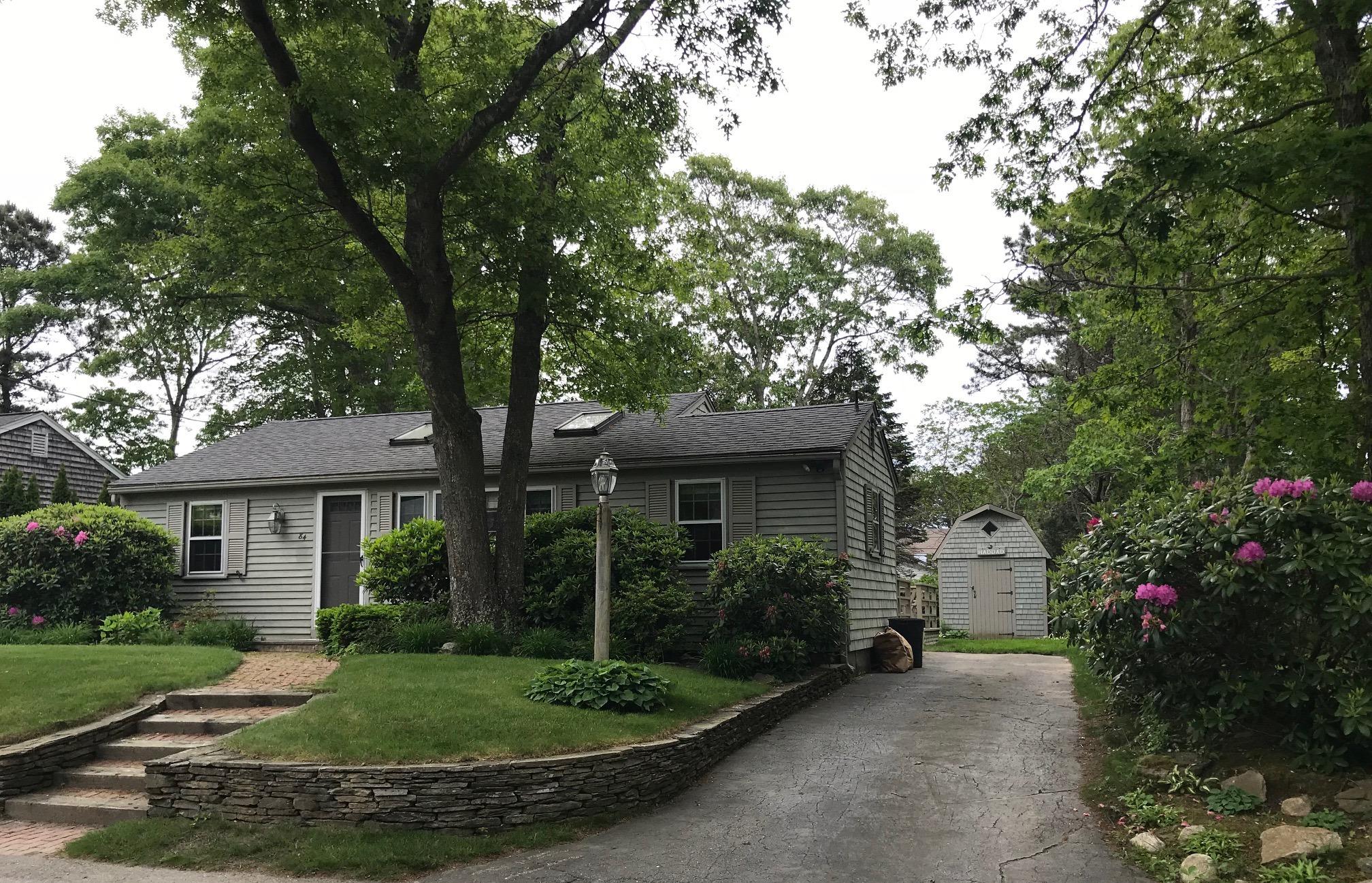 84 Uncle Edwards Road Mashpee, MA 02649 - Photo 1 of 22 a view of a house with a small yard and a large tree