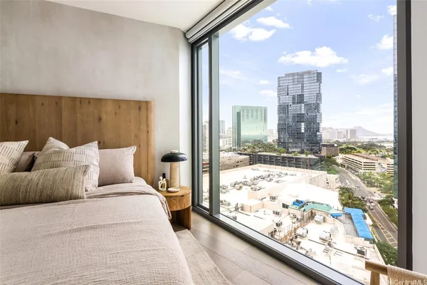 a large bed sitting in a bedroom next to a window