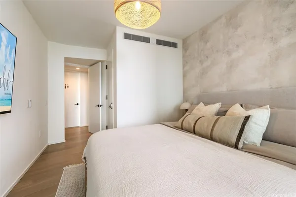 a bedroom with a bed and painting on the wall