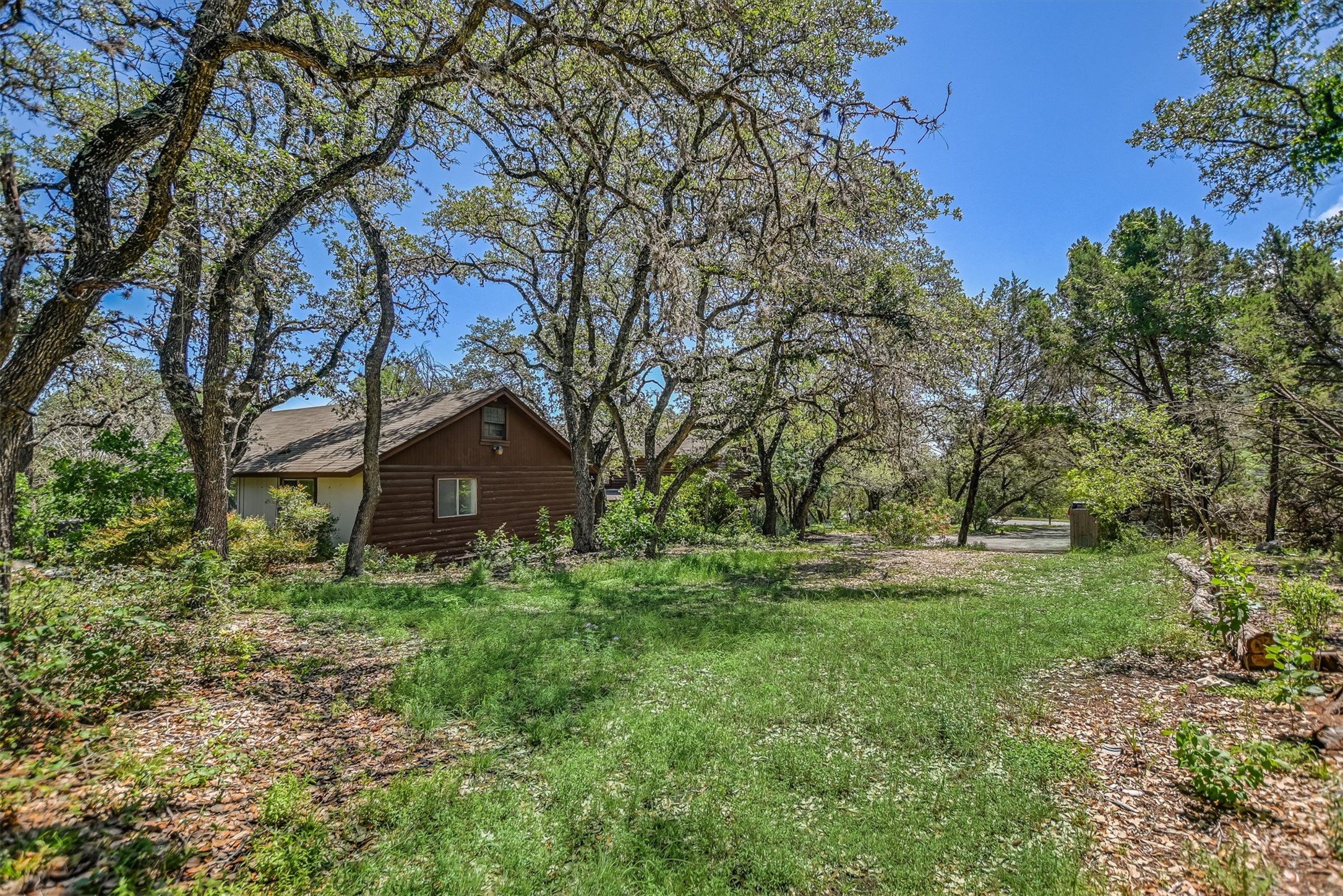 12711 Rr, Unit 12 Wimberley, TX 78676 - Photo 19 of 20 Mature trees across the nearly one-acre property provide a natural screen from the road while maintaining the Wimberley landscape