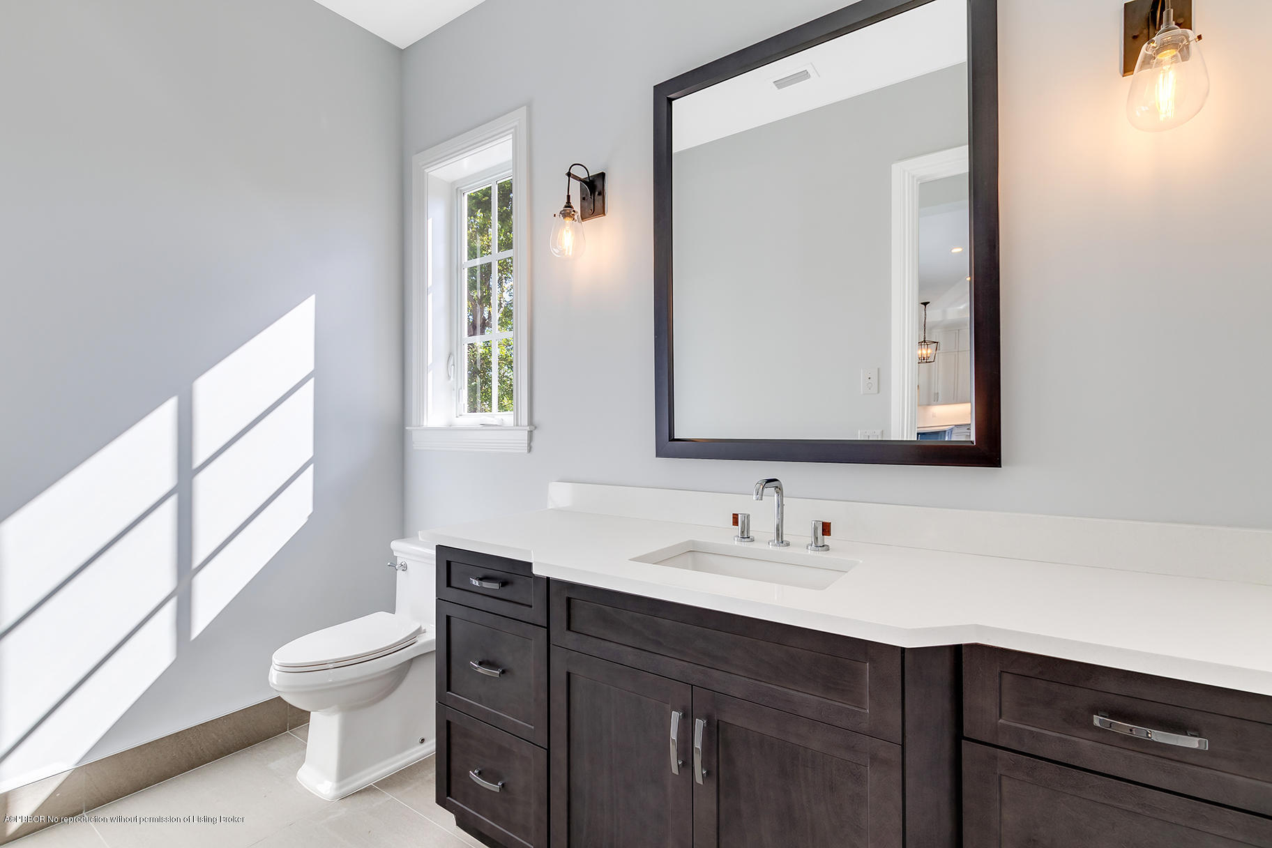200 Costello Road West Palm Beach, FL 33405 - Photo 22 of 28 a bathroom with a toilet a sink a mirror and a window