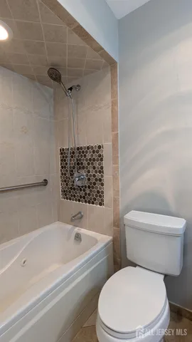 a white toilet sitting next to a bath tub and shower