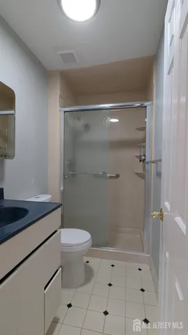 a bathroom with a granite countertop sink a toilet and shower
