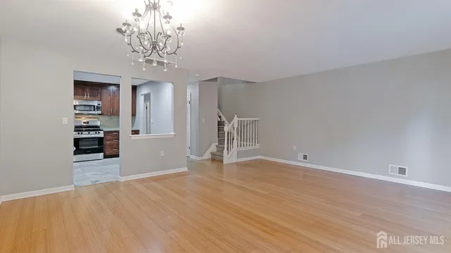 a view of empty room with wooden floor and window