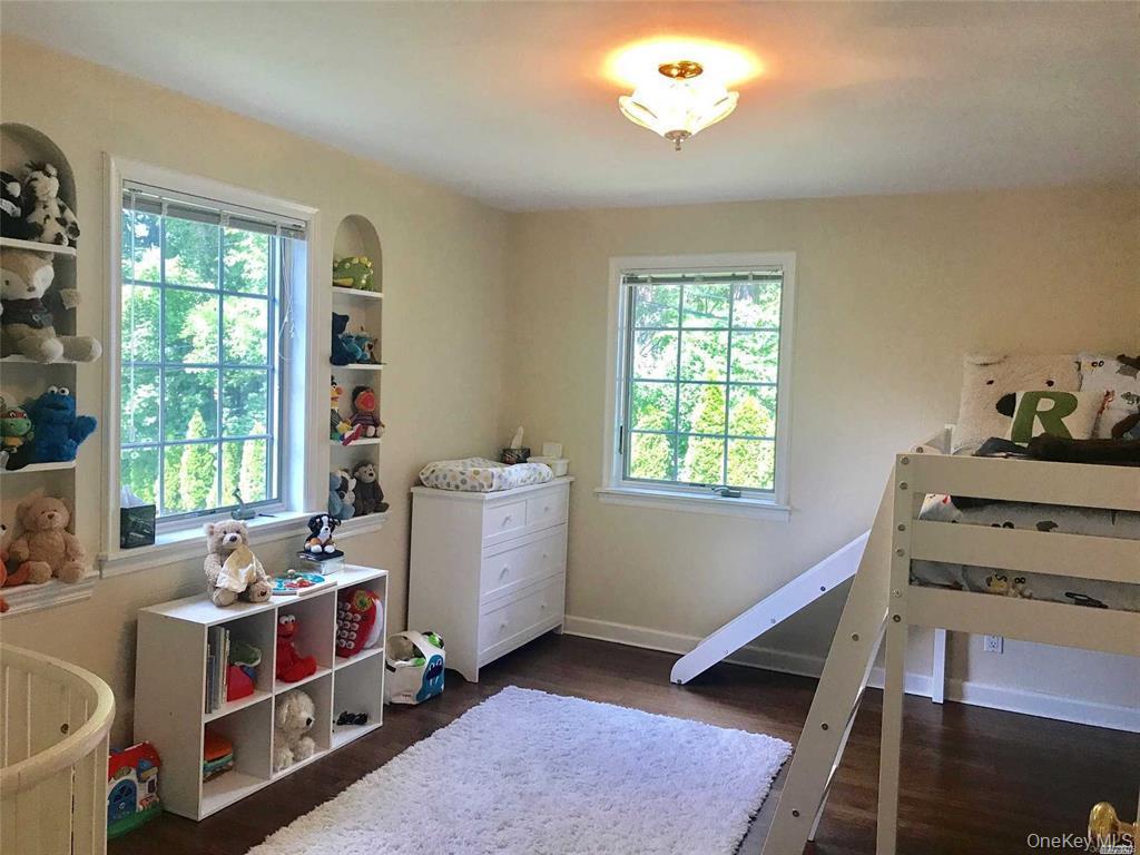 5 Rockcrest Road Manhasset, NY 11030 - Photo 14 of 16 Bedroom with multiple windows, dark wood-type flooring, and baseboards