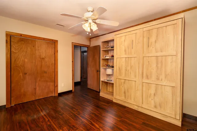 a view of a bedroom with wooden floor and furniture