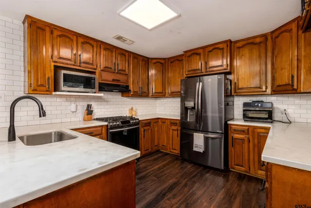 a kitchen with stainless steel appliances granite countertop a stove and a sink