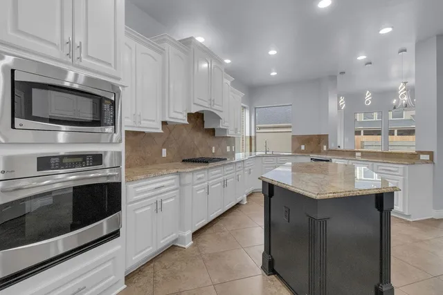 a kitchen with granite countertop stainless steel appliances and white cabinets