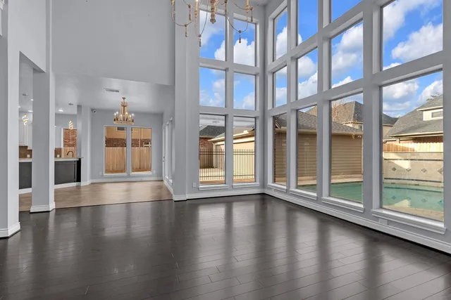 a view of an empty room with wooden floor and a fireplace