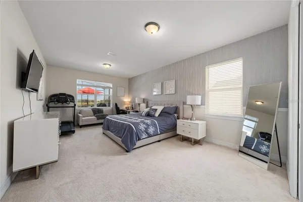 a bedroom with furniture and a flat screen tv