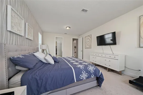 a bedroom with a bed and a flat screen tv
