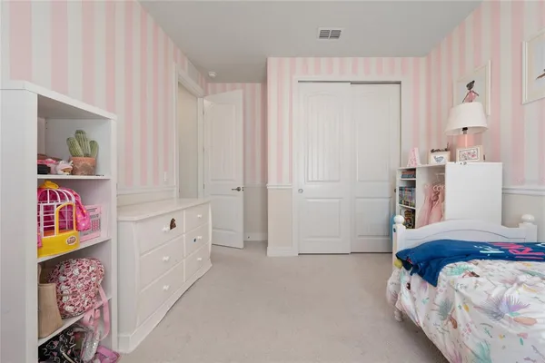 a bedroom with a bed and a painting on the wall