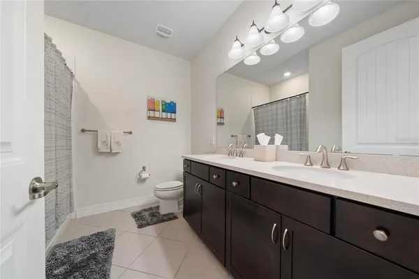 a spacious bathroom with a double vanity sink mirror and toilet