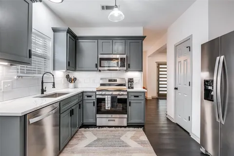 a kitchen with stainless steel appliances a stove sink microwave and refrigerator