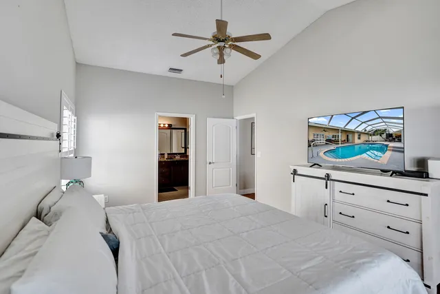 a view of a hallway with wooden floor and a bathroom