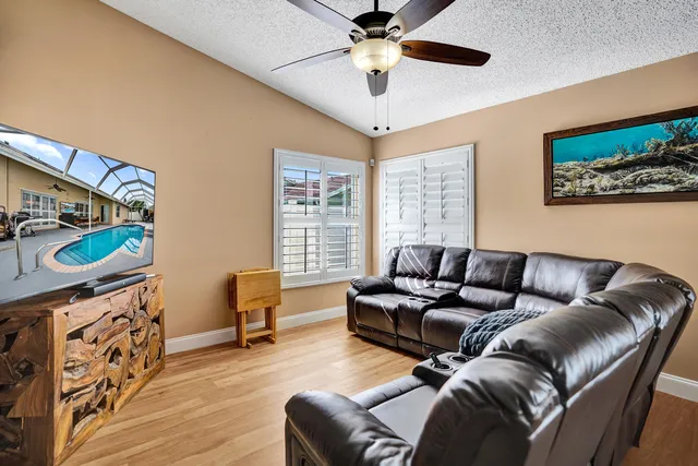 a kitchen with stainless steel appliances granite countertop a refrigerator a sink dishwasher a stove and white countertops with wooden floor