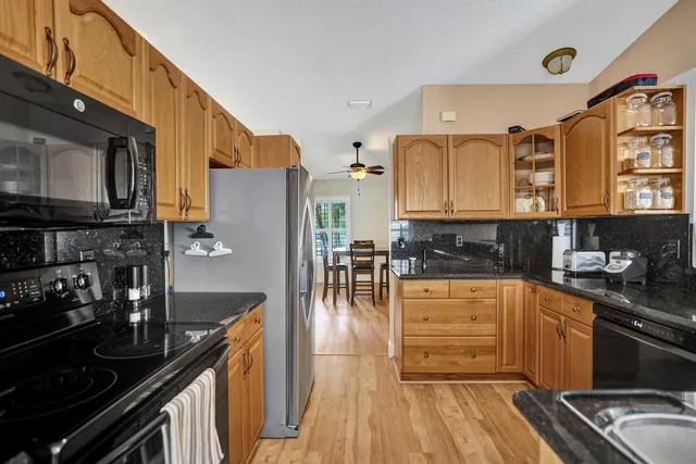a view of a backyard with table and chairs under an umbrella