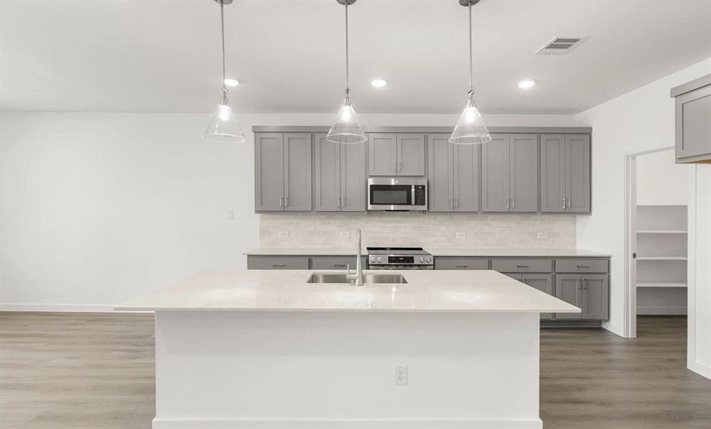 1008 Colgate Circle Princeton, TX 75407 - Photo 11 of 29 a kitchen with kitchen island a sink stainless steel appliances and cabinets