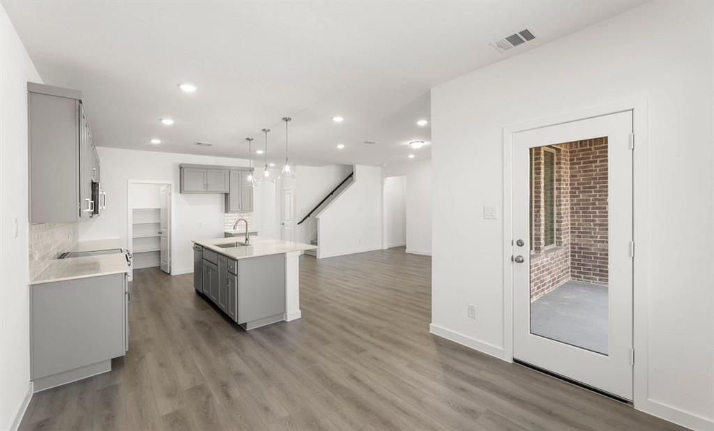 1008 Colgate Circle Princeton, TX 75407 - Photo 15 of 29 a view of a kitchen with white cabinets and wooden floor