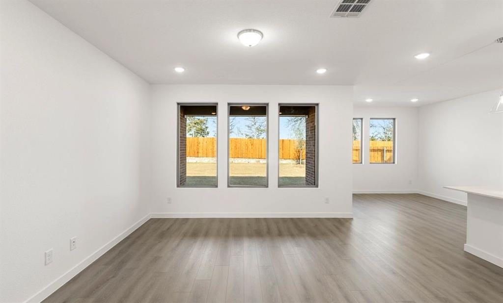 1008 Colgate Circle Princeton, TX 75407 - Photo 16 of 29 an empty room with wooden floor and windows