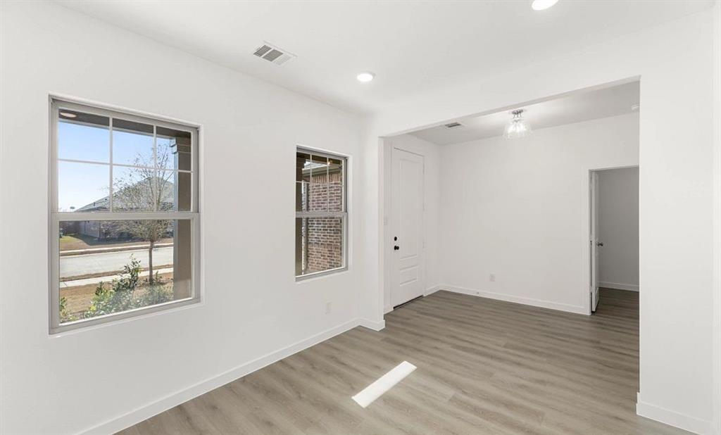 1008 Colgate Circle Princeton, TX 75407 - Photo 9 of 29 a view of an empty room with wooden floor and a window