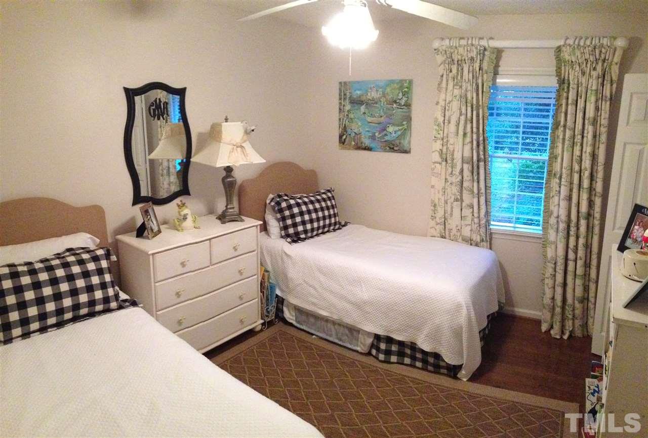 2109 Hillock Drive Raleigh, NC 27612 - Photo 11 of 23 a bedroom with a bed wooden floor and dresser
