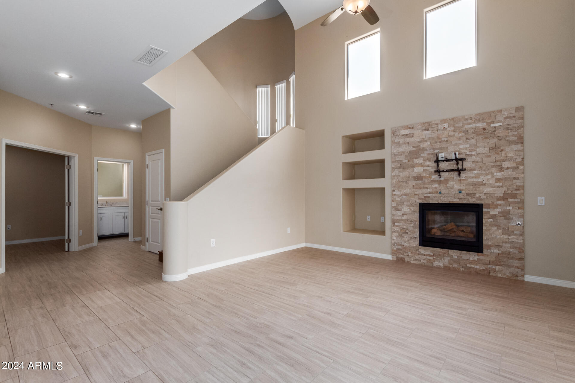 19475 North Grayhawk Drive, Unit 1100 Scottsdale, AZ 85255 - Photo 11 of 54 an empty room with wooden floor fireplace and windows