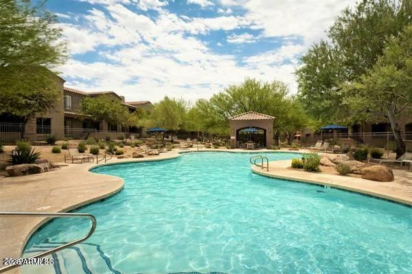 19475 North Grayhawk Drive, Unit 1100 Scottsdale, AZ 85255 - Photo 44 of 54 a view of a swimming pool with a table and chairs