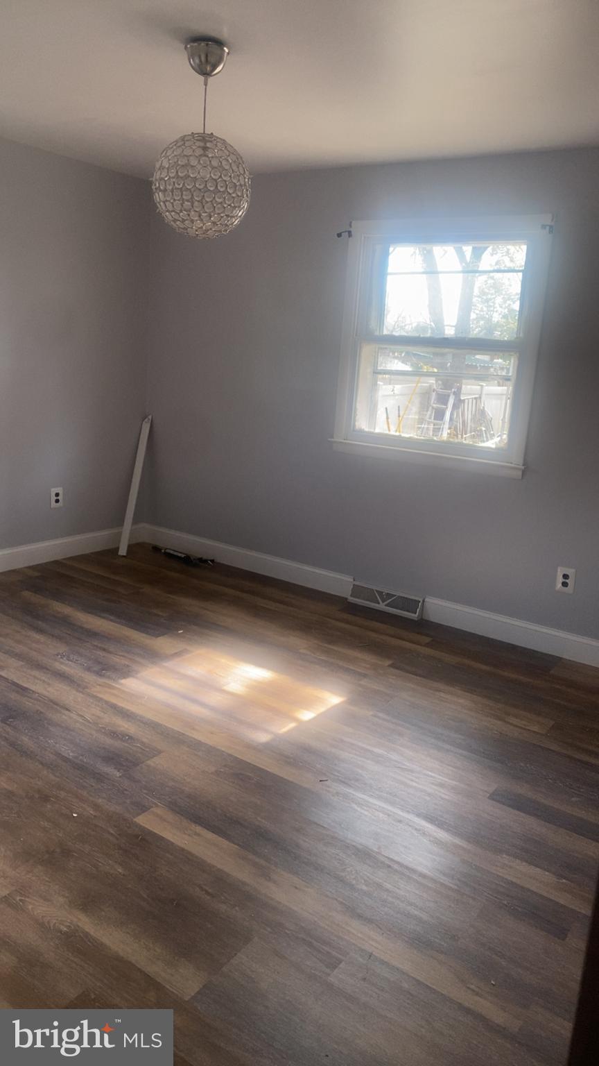 307 Burlington Avenue Delanco, NJ 08075 - Photo 2 of 6 an empty room with wooden floor and windows