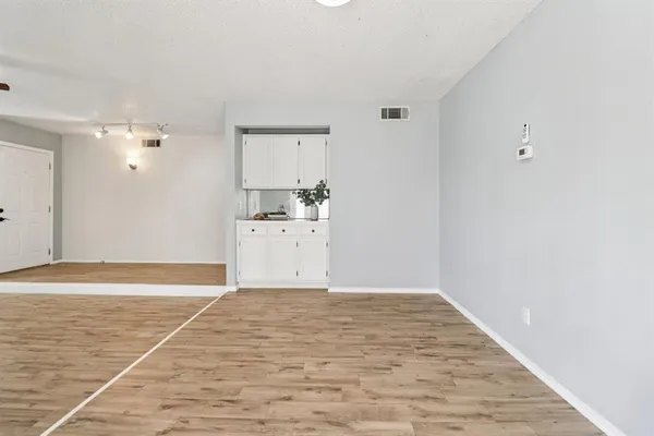 a view of a room with wooden floor and cabinet