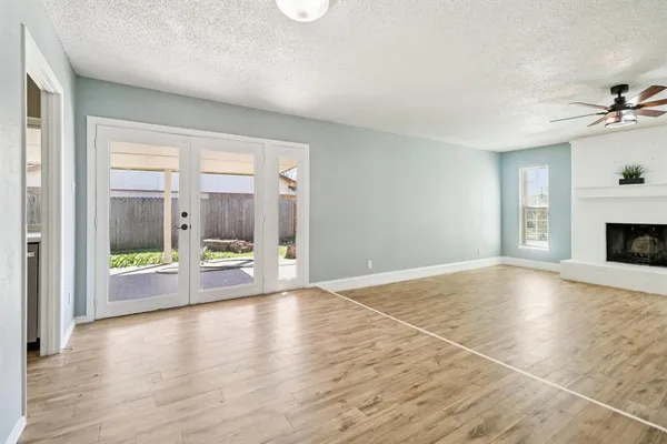 a view of an empty room with a fireplace and a window