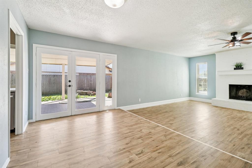 3216 Red Oak Lane Bedford, TX 76021 - Photo 13 of 40 a view of an empty room with a fireplace and a window