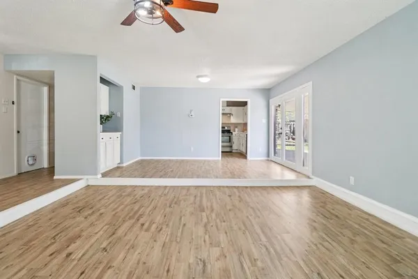 a view of empty room with wooden floor