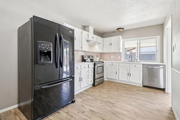 a kitchen with stainless steel appliances a refrigerator sink and cabinets